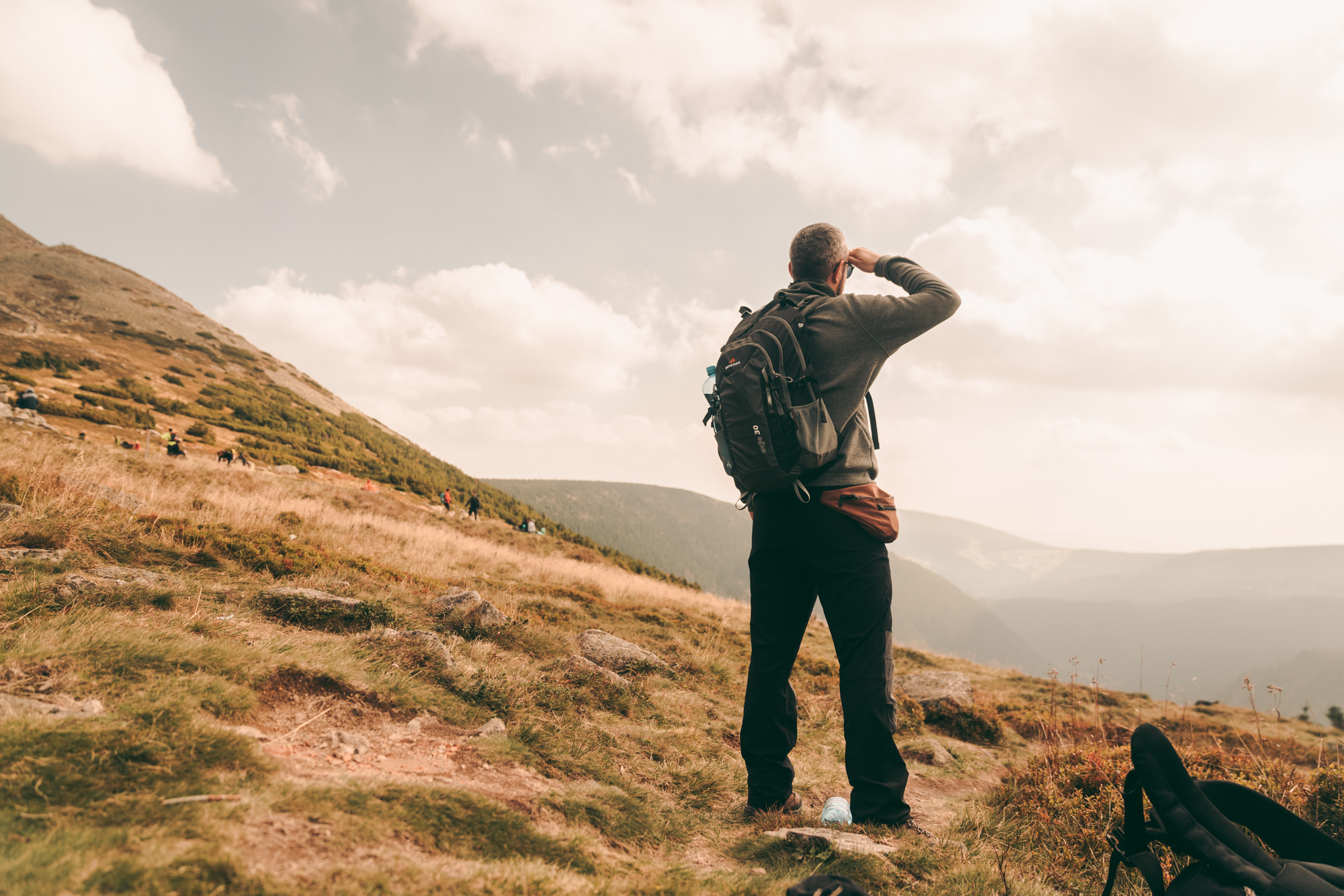 mężczyzna w ubraniu trekkingowym w górach